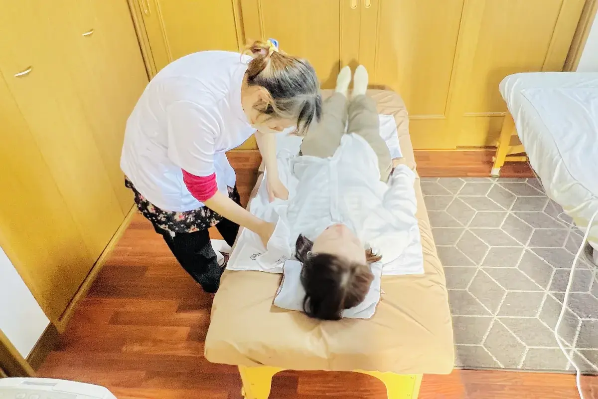 仰向けで腕や足の施術を受ける様子